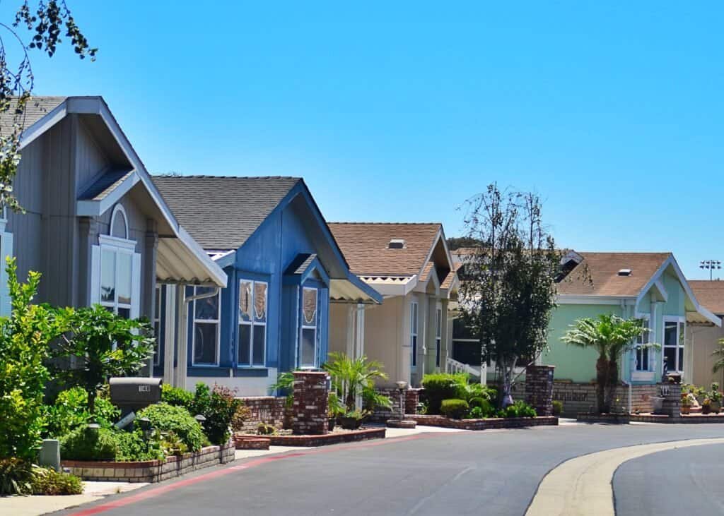 Colorful houses in a well-maintained neighborhood with lush greenery.